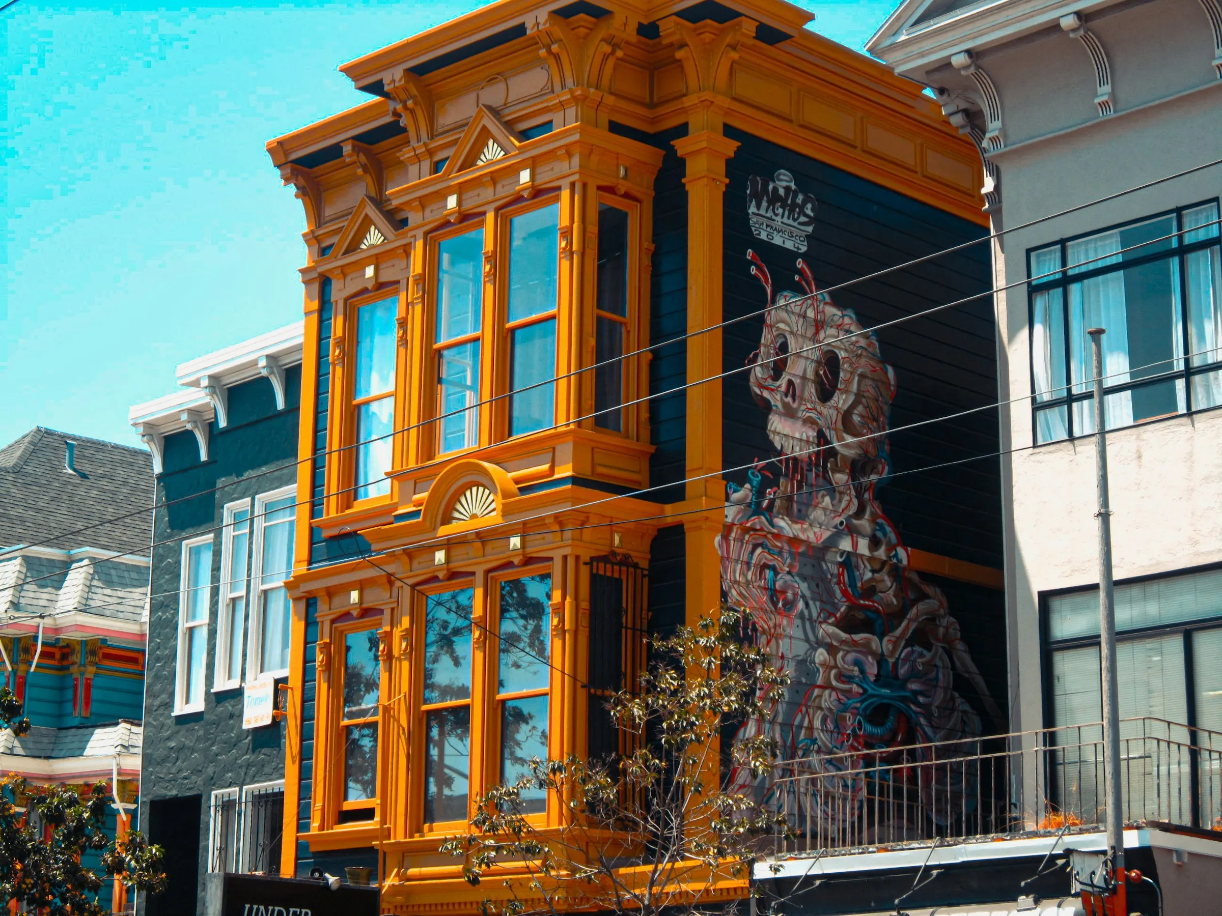 Colorful Victorian house in San Francisco with detailed facade and mural artwork