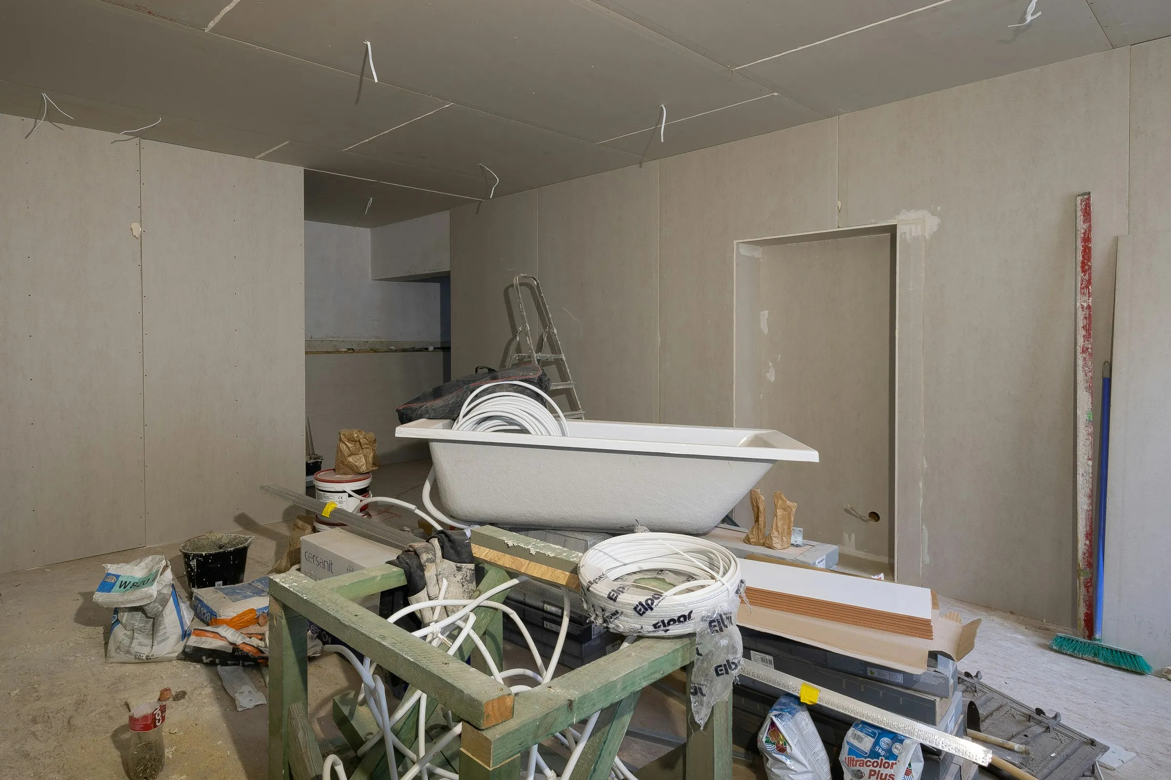 Bathroom renovation in progress with exposed structure and unfinished surfaces