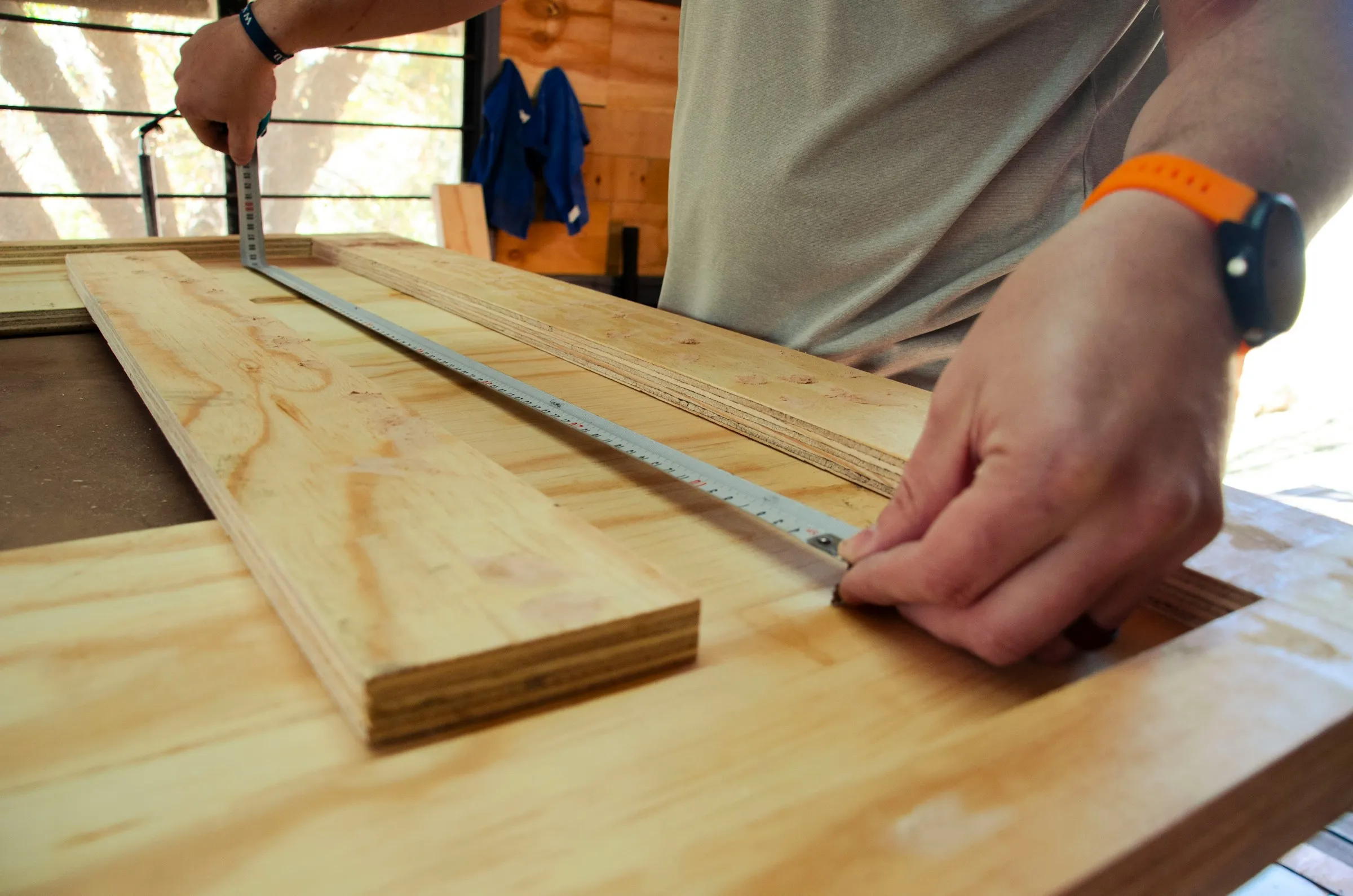 Carpenter measuring wood with tools during construction work