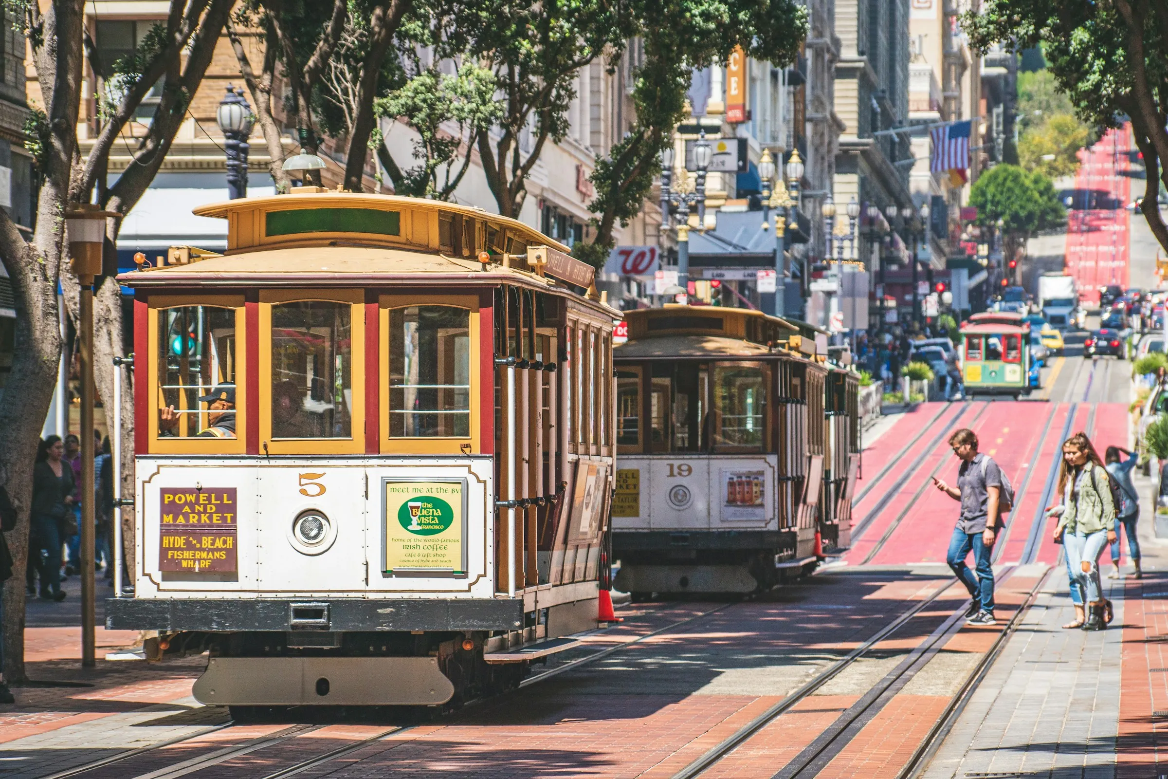 San Francisco cable cars on Powell Street with pedestrians and city backdrop