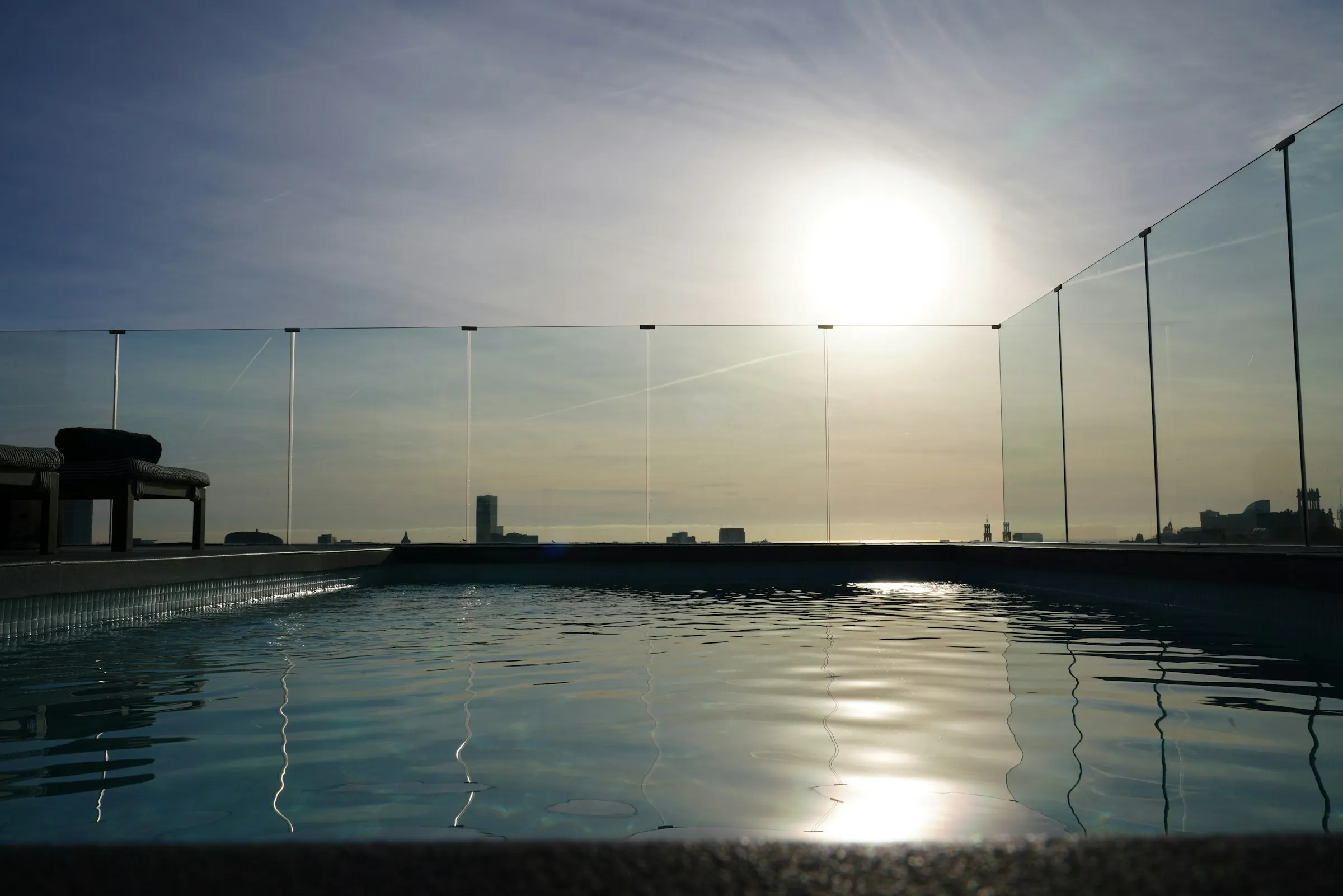 Glass enclosure surrounding a swimming pool for safety and visibility